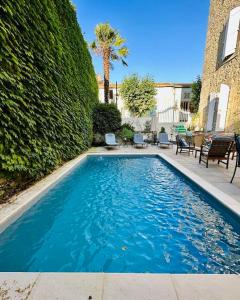 una piscina en un patio junto a un seto en Chambres d'hôtes Relais Mira Peis en Mirepoix