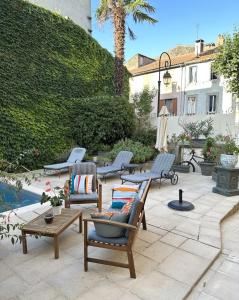 eine Terrasse mit Stühlen, einem Tisch und einem Pool in der Unterkunft Chambres d'hôtes Relais Mira Peis in Mirepoix