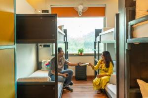 um homem e uma mulher num dormitório com beliches em goSTOPS Delhi em Nova Deli