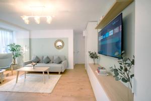 Una sala de estar con un sofá y un televisor. en Urban Nest by the Station, en Bucarest