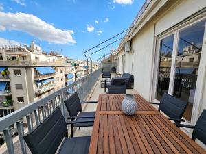 d'une table et de chaises en bois sur un balcon. dans l'établissement Victoria Capitan Apartments, à Athènes