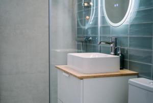 Un baño con lavabo blanco y ducha. en Urban Nest by the Station, en Bucarest 25 fotos más