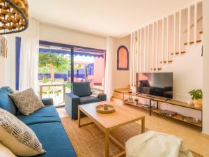 un salon avec un canapé bleu et une télévision dans l'établissement Meloneras Ocean Escape by CanaryScape, à San Bartolomé