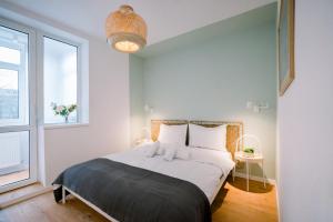 Un dormitorio con una cama con almohadas blancas y una ventana en Urban Nest by the Station, en Bucarest