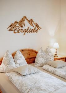 duas camas com almofadas brancas e um sinal na parede em Ferienwohnungen Baumann-Breitenberg em Sankt Georgen am Reith