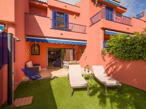 un patio avec des chaises et une table devant un bâtiment dans l'établissement Meloneras Ocean Escape by CanaryScape, à San Bartolomé