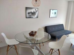 a dining room with a glass table and a blue couch at Appartement GALA in Pulpí