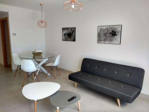 a living room with a black couch and a table at Appartement GALA in Pulpí