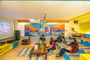 eine Gruppe von Personen, die auf Sofas in einem Raum sitzen in der Unterkunft goSTOPS Delhi in Neu-Delhi