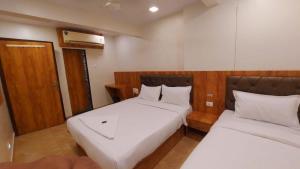 Postel nebo postele na pokoji v ubytování HOTEL RIGGA INN KOKILABEN DHIRUBHAI AMBANI Hospital