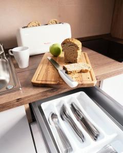 a cutting board with bread and an apple on a counter at Summerlandrota Veracruz28 in Rota