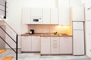 a kitchen with white cabinets and a sink at Summerlandrota Veracruz28 in Rota +9 photos