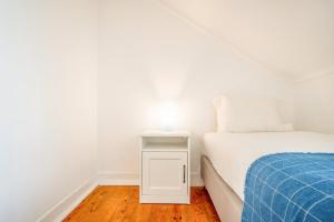 a bedroom with a bed and a white night stand at GuestReady - B-MAD Museum At Your Doorstep in Lisbon