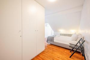 biała sypialnia z łóżkiem i szafą w obiekcie GuestReady - B-MAD Museum At Your Doorstep w Lizbonie