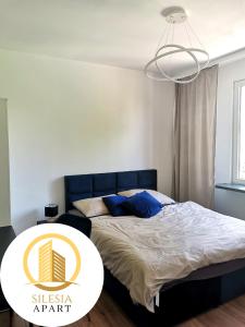 a bedroom with a bed with a table in it at Apartament Granatowy in Tychy