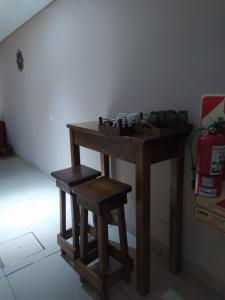 uma mesa de madeira com dois bancos num quarto em Lujan Homes em Luján