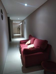 uma sala de estar com um sofá vermelho num corredor em Lujan Homes em Luján