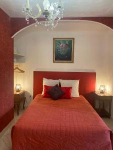 1 dormitorio con 1 cama roja y 2 almohadas en Maison d'hôtes Le Beauséjour, en Carcassonne