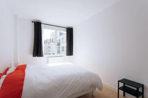 um quarto com uma cama e uma janela em GuestReady - Calm and Charm near Bois de Boulogne em Saint-Cloud