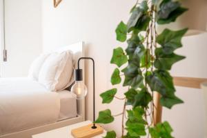 a bedroom with a bed and a table with a plant at GuestReady - Salty Retreat in Trafaria in Costa da Caparica