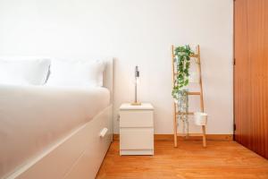 a white bedroom with a bed and a ladder at GuestReady - Salty Retreat in Trafaria in Costa da Caparica