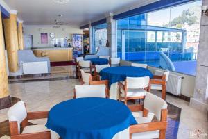 Hotel Lago Azul في كوباكابانا: مطعم بالطاولات الزرقاء والكراسي البيضاء