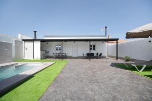 Un patio trasero con piscina y una casa. en Joal Piscina Privada, en Chiclana de la Frontera