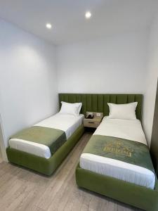 2 Betten nebeneinander in einem Zimmer in der Unterkunft Reign Hotel in Vorë
