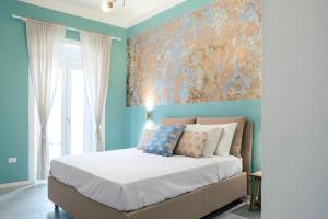 1 dormitorio con 1 cama con una pintura en la pared en VALÚ en Carloforte