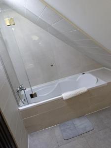 y baño con bañera y espejo. en Pension Casa Contelui, en Râșnov