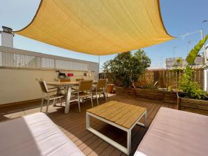 un patio con mesa y sillas en una terraza en Luxury Duplex 200 M2 Terrace Parking StayInSeville, en Sevilla
