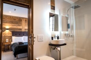 uma casa de banho com um lavatório, um chuveiro e uma cama. em Nant Morzine em Morzine