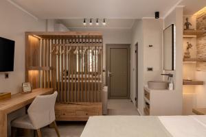um quarto com uma cama, uma secretária e um lavatório. em Chrissida Hotel em Nea Kydonia