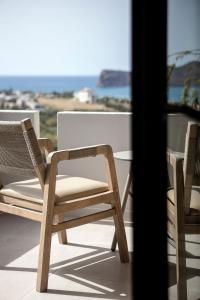 Duas cadeiras numa varanda com vista para o oceano em Chrissida Hotel em Nea Kydonia