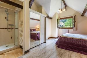 a bedroom with a shower and a bed in a room at Les Chenes, avec piscine, tennis et lac privatif in Guerquesalles