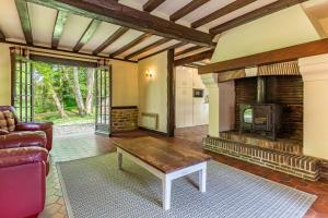 a living room with a couch and a fireplace at Les Chenes, avec piscine, tennis et lac privatif in Guerquesalles