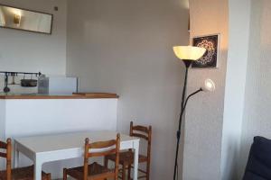 a dining room with a table and a lamp at Maison sur mer in Palavas-les-Flots
