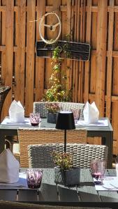 a table with chairs and plants on a wooden wall at Vötter's Hotel - summer card included in Kaprun