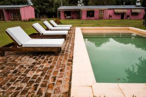 a group of lounge chairs sitting next to a pool at Posada Mbarete in San Miguel