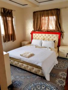 um quarto com uma cama grande e uma cabeceira vermelha em Résidence London em El Aiune
