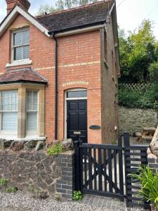 a brick house with a black door at Summerfield in Little Malvern