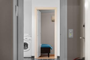 a door leading into a laundry room with a washing machine at Forenom Serviced Apartments Oslo Nobel in Oslo