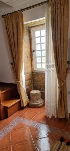 een kamer met gordijnen, een raam en een vloer bij Stone House in Salzedas