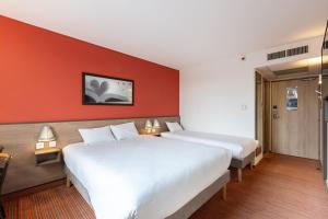 - 2 lits dans une chambre d'hôtel aux murs rouges dans l'établissement Ace Hotel Chateauroux Déols, à Déols