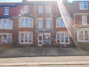 ein großes rotes Backsteingebäude mit dem Eingang zu einem Laden in der Unterkunft Hesketh Hotel in Blackpool