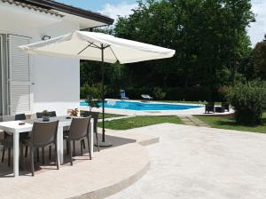 een patio met een tafel en een parasol naast een zwembad bij casa stefano 