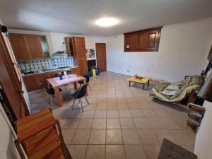 uma cozinha e sala de estar com mesa e cadeiras em Casa di montagna em Aisone