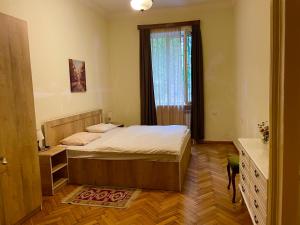 um quarto com uma cama grande e uma janela em vake em Tbilisi