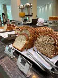 a bunch of different types of bread on a counter at Hotel Alji in Indaiatuba