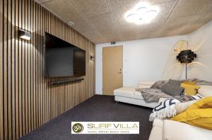 - un salon avec un canapé et une télévision dans l'établissement Surf Villa, à Vääna-Jõesuu